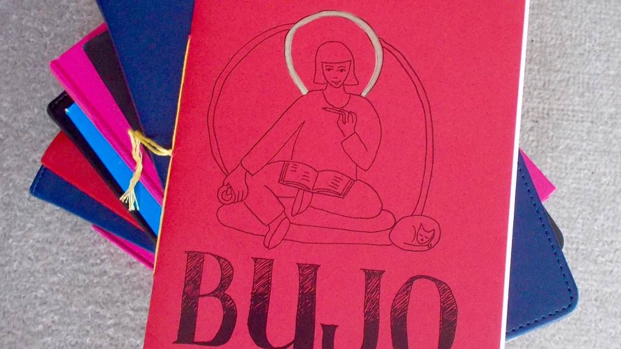 Red book cover with line drawing of woman sitting in lotus position with open book on her lap and gold semicircle around head and shoulders, BUJO in big letters at bottom.